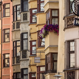 Farbenfrohe historische Häuserfassaden mit kunstvollen Erkern und Blumenschmuck in der Innsbrucker Altstadt.