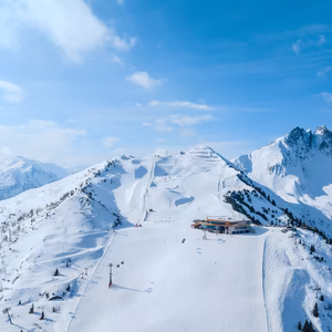 Winterliches Panorama des Skigebiets an der Spieljochbahn mit präparierten Pisten, Bergstation und schneebedeckten Gipfeln.
