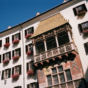 Nahansicht des Goldenen Dachls mit kunstvoll verziertem Erker und blumengeschmückter Fassade in der Innsbrucker Altstadt.